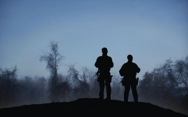 Two security personnel standing guard at dawn