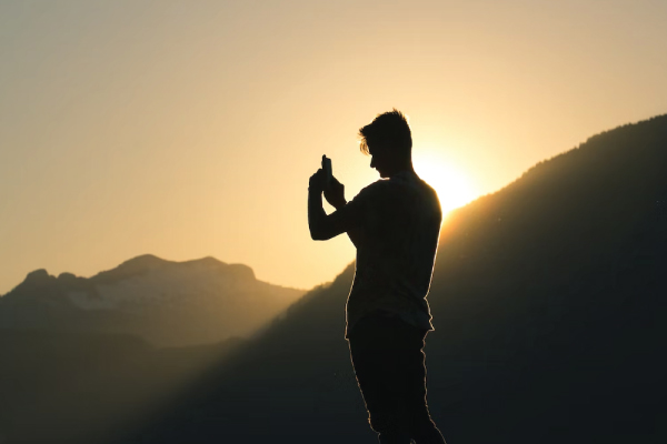 Hiker on Phone in Mountains