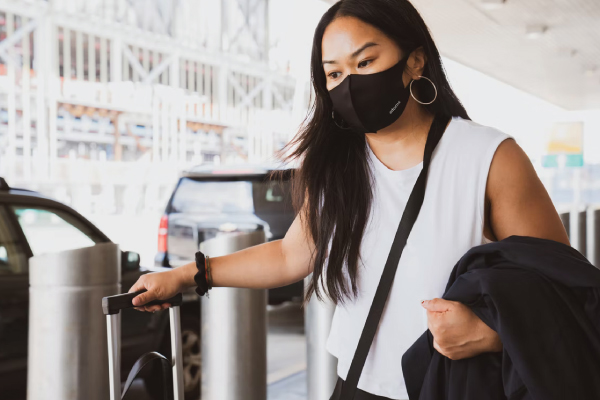Female Traveler at the Airport With Mask on