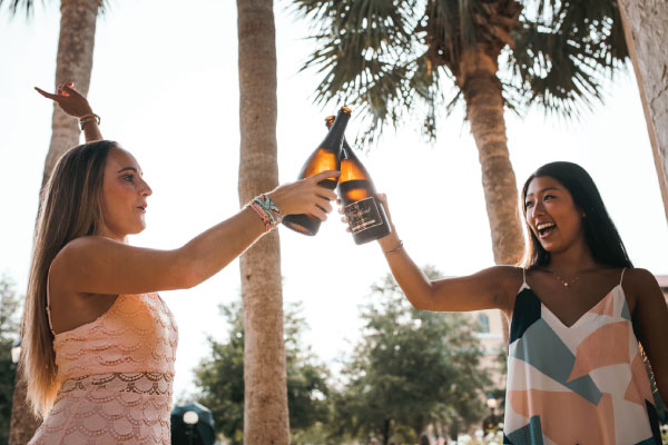 Two women on vacation with travel insurance drinking